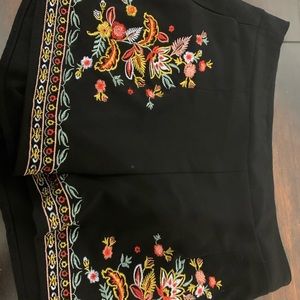 Black embroidered shorts. Colorful detailing.